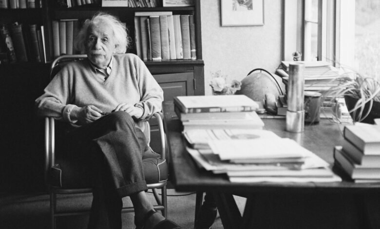 اختبار ألبرت أينشتاين: ماذا تعرف عن حياة عالم الفيزياء النظرية الشهير؟ 1 Einstein sitting at his desk
