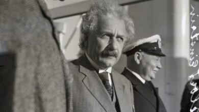 a black and white photo of Einstein standing in a line of men