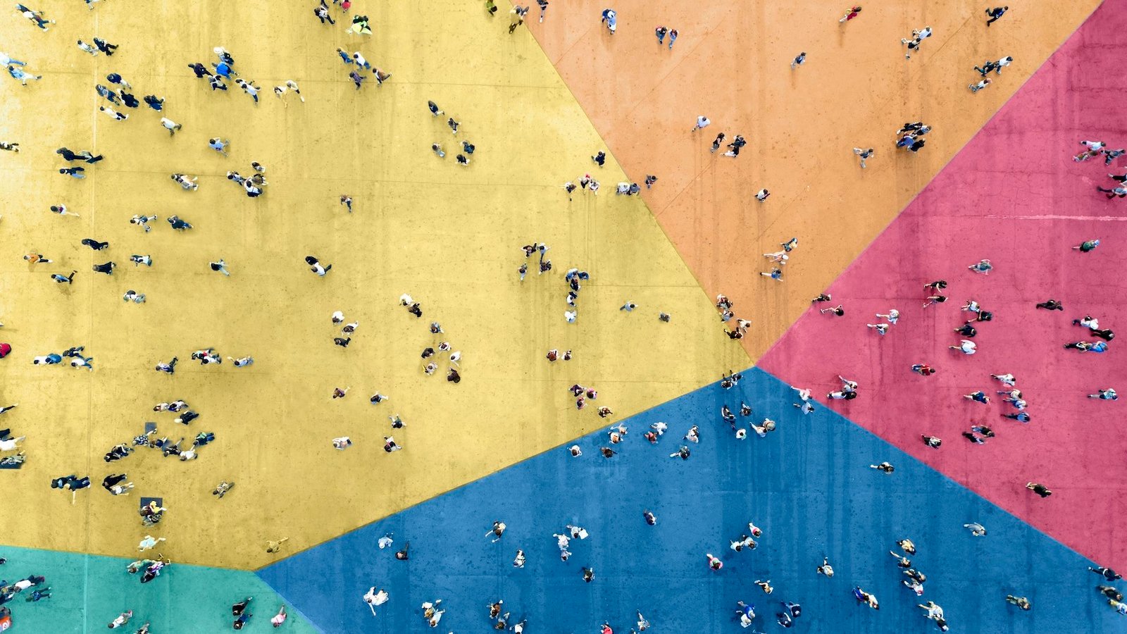 a bird's eye view of a crowd of people on a multicolored floor