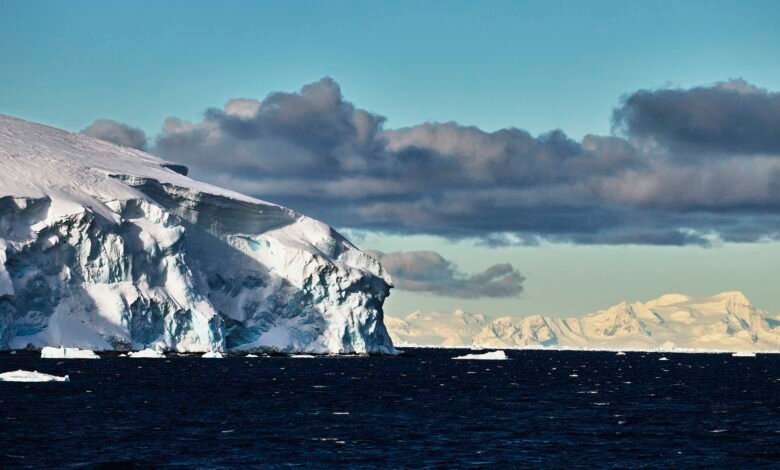 "عواقب سلبية خطيرة وغير مقصودة": الهندسة الجيولوجية القطبية ليست الحل لتغير المناخ 1 a photo of the edge of a glacier with ominous clouds in the background