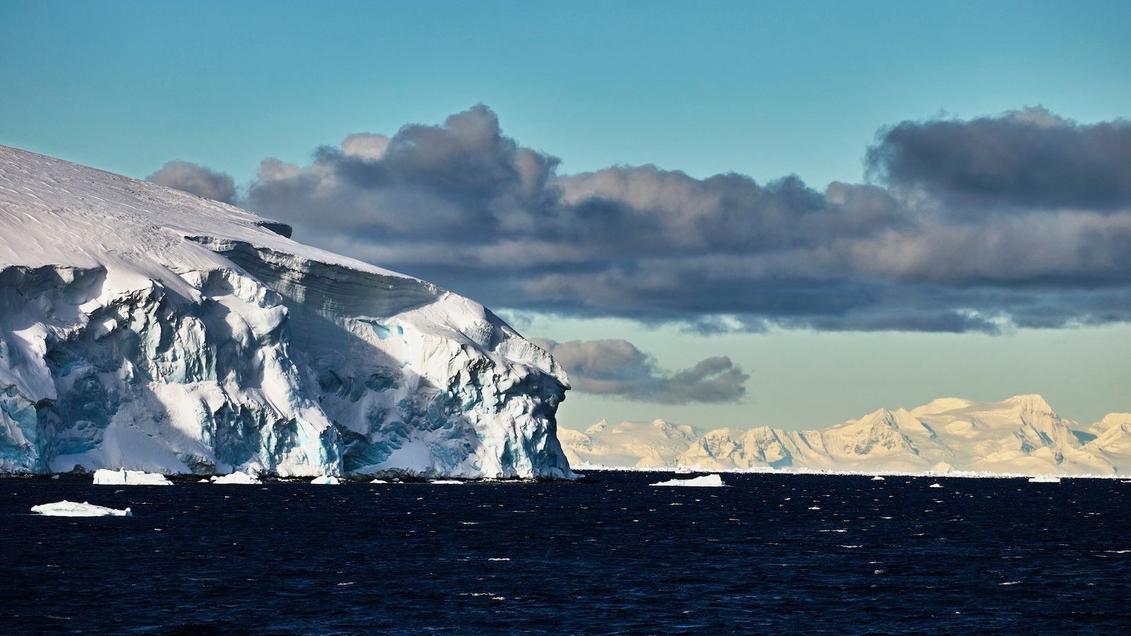 "عواقب سلبية خطيرة وغير مقصودة": الهندسة الجيولوجية القطبية ليست الحل لتغير المناخ 5 a photo of the edge of a glacier with ominous clouds in the background