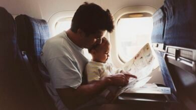 a father hold his infant son on an airplane