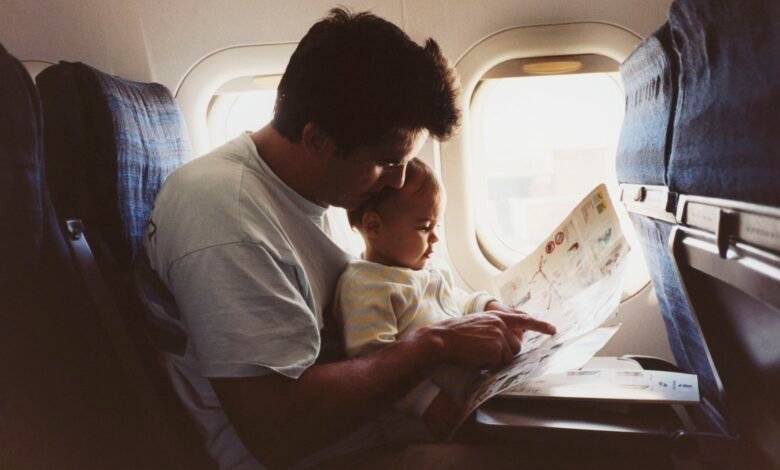 ما هو المقعد الأكثر أمانا على متن الطائرة؟ 1 a father hold his infant son on an airplane