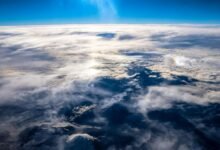 a photograph of Earth's surface taken from above the clouds