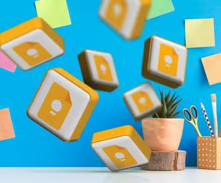 several google keep logos on a desk with some notes in the background